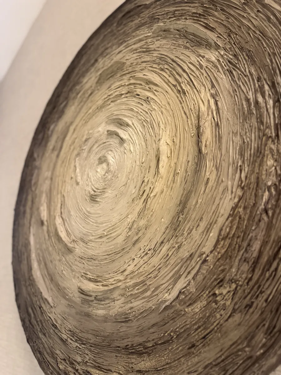 Detail of a Mar de Ensueños panel: a bronze-toned spiral of layered texture